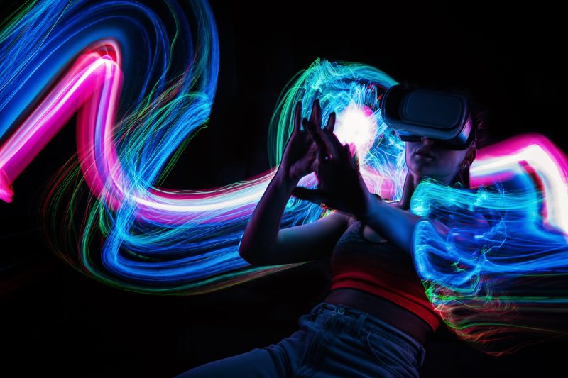 Metaverse digital Avatar, Metaverse Presence, digital technology, cyber world, virtual reality, futuristic lifestyle. Woman in VR glasses playing AR augmented reality NFT game with neon blur lines.